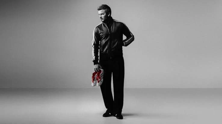 David Beckham holding a white and red adidas Predator Precision