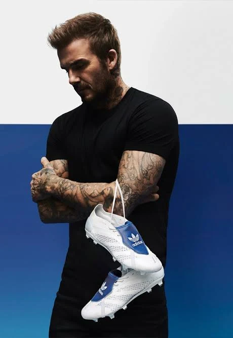 David Beckham holding a pair of adidas Predators by the laces