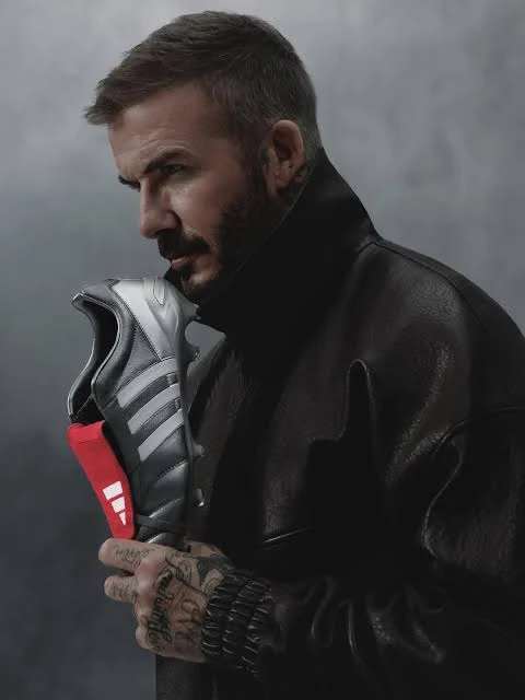 David Beckham holding an adidas Predator with a red fold-over tongue